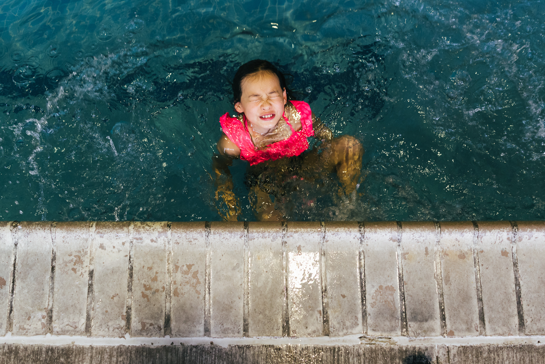girl with silly face in pool
